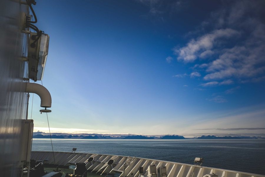 Calm open ocean and blue sky seen from a ship deck